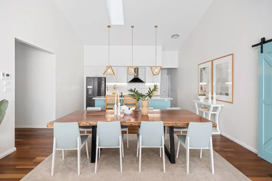 Bright dining room with a vaulted ceiling and timber table