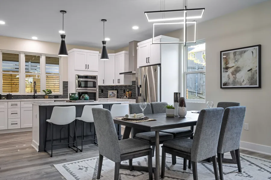Monochrome kitchen and dining room with a dark island bench